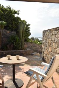 a patio with a table and chairs and a cactus at Olous Secret Hideaway - Sea View Studio Elounda in Elounda