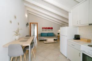 a kitchen and living room with a table and a couch at Fissas Rooms in Syvota