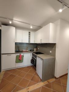 a kitchen with white cabinets and a stove top oven at Gigi Beachfront in Ferrel