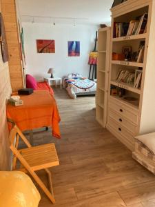 a room with a bed and a table and a book shelf at Studio à la Ferme in Limpiville