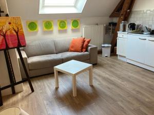 a living room with a couch and a table at Studio à la Ferme in Limpiville