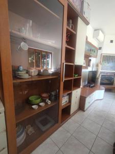 a kitchen with wooden shelves with dishes in it at Villa Maddalena Brianza in Lentate sul Seveso