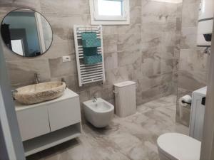 a bathroom with a sink and a toilet and a mirror at Villa Maddalena Brianza in Lentate sul Seveso +8 photos
