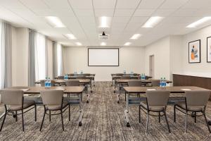 a conference room with tables and chairs and a whiteboard at Garner Hotel Houston - Westchase by IHG in Houston +47 photos