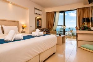 a bedroom with a large bed and a large window at Kamari Beach in Lartos +84 photos