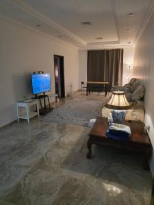 a living room with a couch and a television at Khiran City in An Nāmī