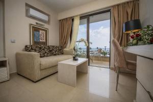 a living room with a couch and a table at Kamari Beach in Lartos
