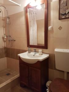 Un baño con lavabo, inodoro y espejo. en Central Square Studios, en Sibiu