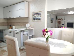 a kitchen with a table with a vase of flowers on it at Apartman ANA in Pirot
