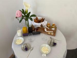 a table with plates of food and a vase with flowers at Les Terres Noires in Serville