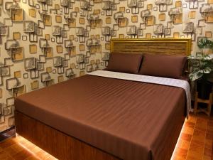 a large bed in a bedroom with a wall at Airi Homestay in Suvarnabhumi Airport