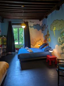 a bedroom with a bed with a painting on the wall at La Tuilerie Du Cinéaste in Courlon