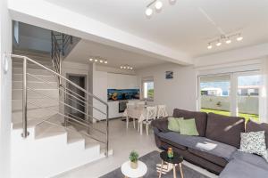 a living room with a couch and a staircase at Apartment Sankovic in Ražanac
