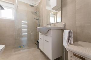 a bathroom with a sink and a toilet and a mirror at Apartment Sankovic in Ražanac +30 photos