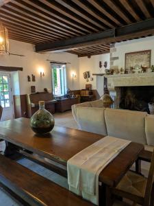 a living room with a table and a fireplace at La Tuilerie Du Cinéaste in Courlon