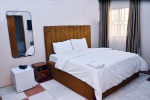 a bedroom with a large bed and a mirror at Peace Vil in Kuto