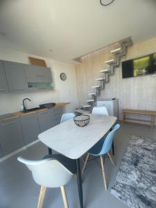 a kitchen with a white table and chairs and stairs at AgroReset in Korlino +17 photos