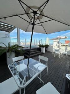 a patio with a table and chairs and an umbrella at MySuites in Montevideo