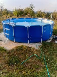a blue hot tub on a deck with a hose at Domacinstvo Jelkici in Zvornik