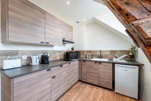 a kitchen with wooden cabinets and a sink at Murray - En plein cœur de Caen in Caen +7 photos