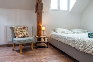 a bedroom with a bed and a chair and a lamp at Murray - En plein cœur de Caen in Caen