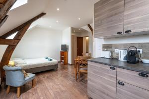 a room with a kitchen with a bed and a table at Murray - En plein cœur de Caen in Caen