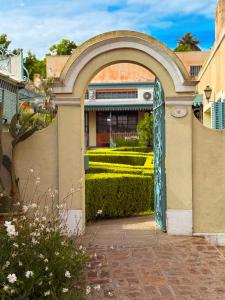 an archway entrance to a building with a garden at Hotel Draghi in San Antonio de Areco