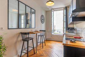a kitchen with two bar stools and a counter at Federer - Dans l'hypercentre de Caen in Caen