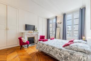 a bedroom with a bed and two chairs and a fireplace at Federer - Dans l'hypercentre de Caen in Caen