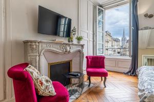 a living room with a fireplace with a tv above it at Federer - Dans l'hypercentre de Caen in Caen