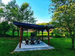 a picnic shelter with a picnic table in a park at Villa Riverside Haven in Hadžići +4 photos