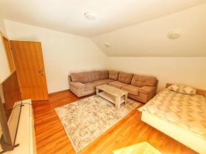 a living room with a couch and a table at Villa Riverside Haven in Hadžići