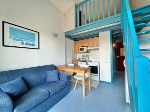 a living room with a blue couch and a table at Hôtel & Résidence Vacances Bleues Orhoïtza in Hendaye