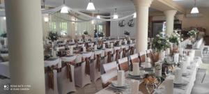a banquet hall with white tables and chairs at Lipa Hotel és Étterem in Szentgotthárd