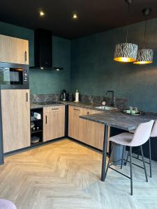 a kitchen with a table and two white chairs at Wellnesslodge Merel jacuzzi sauna and privacy in Dalerveen