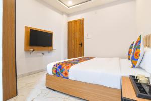 a bedroom with a bed and a tv on the wall at FabHotel Trivana, Mahalaxmi Nagar in Indore