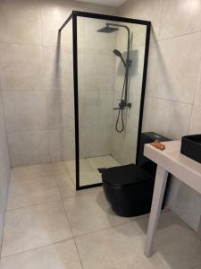a bathroom with a shower with a black stool and a mirror at Toubakouta River Paradise in Toubakouta +66 photos