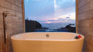 a bath tub in a bathroom with a view of the ocean at Harbor base SHARK in Sado