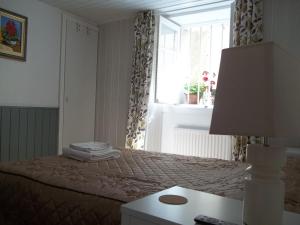 a bedroom with a bed with a window and a lamp at Le Bel Coin in Ginoles