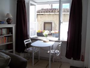 a table and chairs in a room with a window at Le Bel Coin in Ginoles