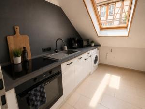 a kitchen with a sink and a dishwasher at Heyne-Ufer City Apartment II - TOP Innenstadtlage in Göttingen +3 photos