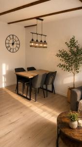 a dining room with a table and chairs and a clock at Heyne-Ufer City Apartment II - TOP Innenstadtlage in Göttingen