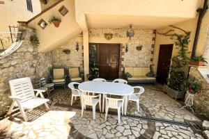 a patio with a white table and chairs at Antico Leccio Green in Coppe