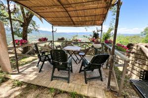 a patio with a table and chairs under a roof at Antico Leccio Green in Coppe
