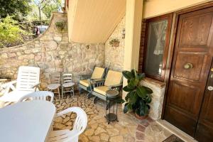 a patio with chairs and a wooden door and a porch at Antico Leccio Green in Coppe +8 photos