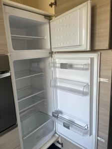 an empty refrigerator with its door open in a kitchen at Casa Vacanza Giorgio Apartment in Gallarate