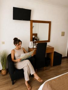 a woman sitting in a chair reading a paper at Verde Pinho in Geres