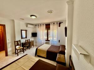 a hotel room with a bed and a dining room at Hotel Entrelagos in Ruidera