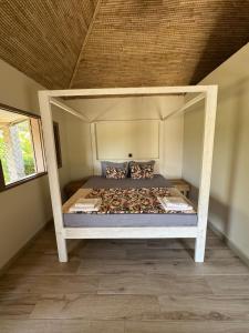 a white bed in a room with a roof at Toubakouta River Paradise in Toubakouta