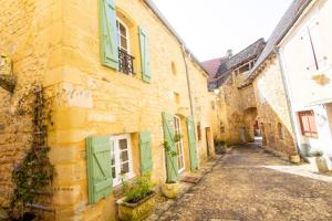 an alley in an old building with green shutters at Le gentil coquelicot in Saint-Pompont